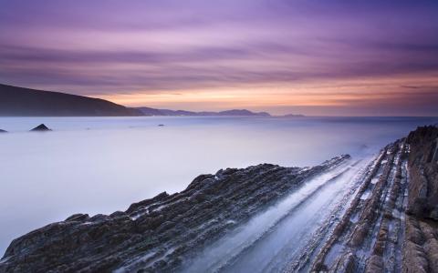 西班牙海滩岩石，海湾，日落壁纸